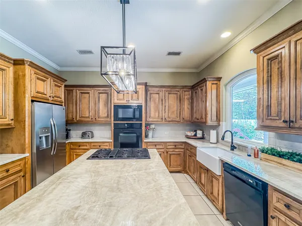 a kitchen with stainless steel appliances granite countertop a stove a sink a oven a dining table and chairs