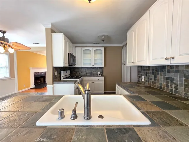 a kitchen with granite countertop a sink and a stove top oven