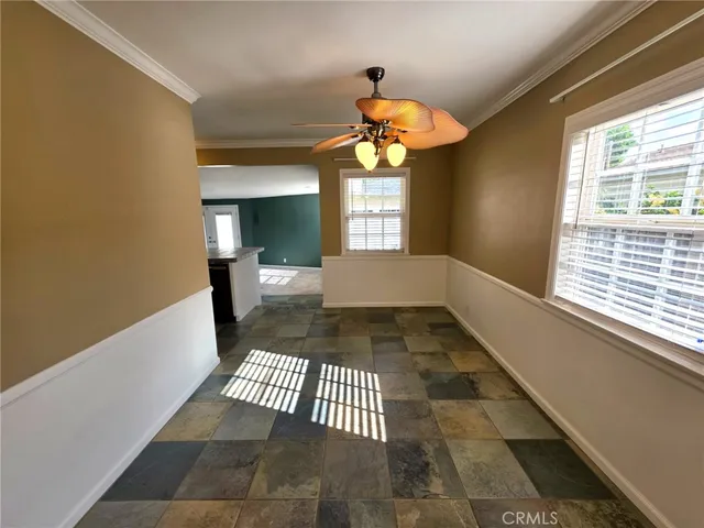 a view of a hallway with wooden floor and a chandelier