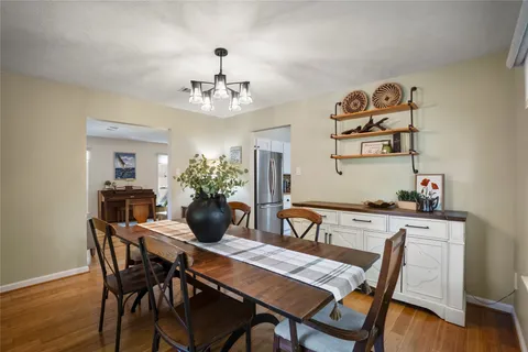 a view of a dining room with furniture wooden floor and a chandelier