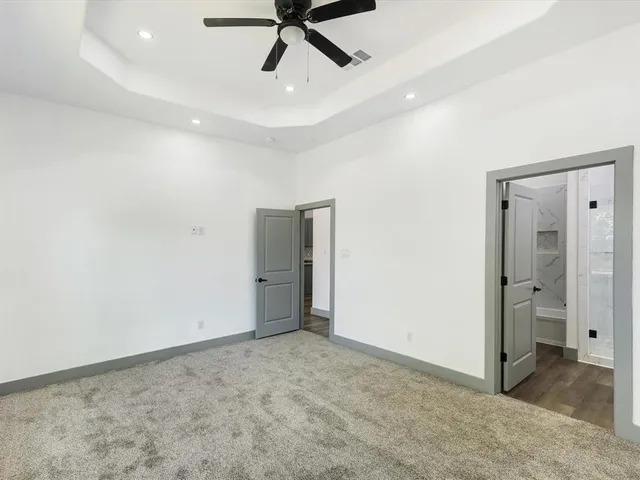 an empty room with window and ceiling fan