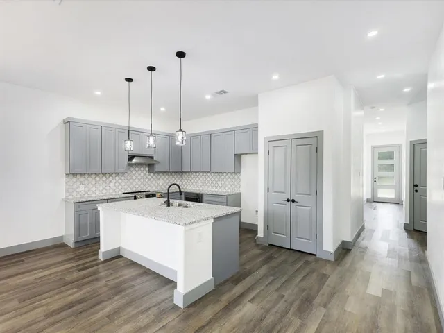 a kitchen with a sink a refrigerator and white cabinets