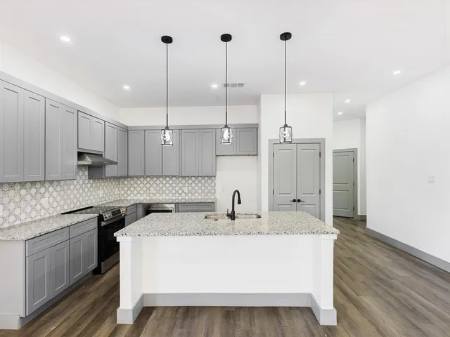 a kitchen with kitchen island a sink stainless steel appliances and cabinets