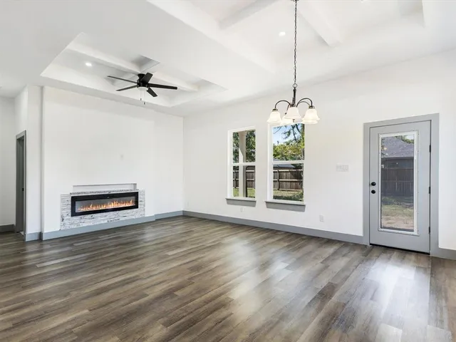 a view of a livingroom with wooden floor and a fireplace