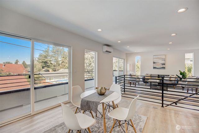 a living room with furniture large window and wooden floor