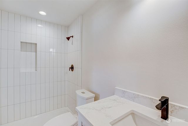 a bathroom with a sink a toilet and shower