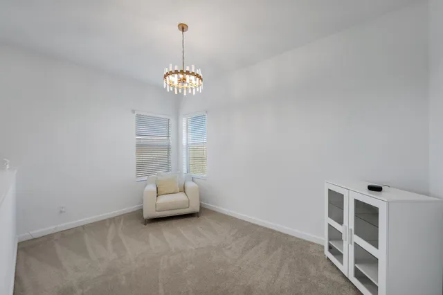 a bedroom with a bed a lamp and a large window