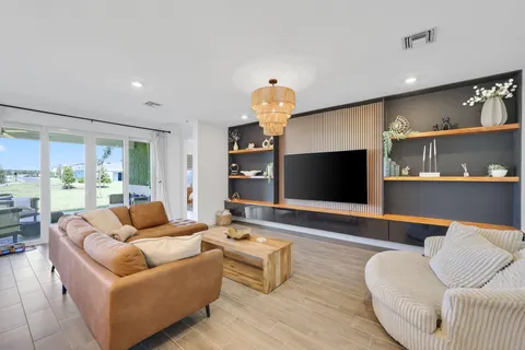 a living room with furniture and a dining table with wooden floor