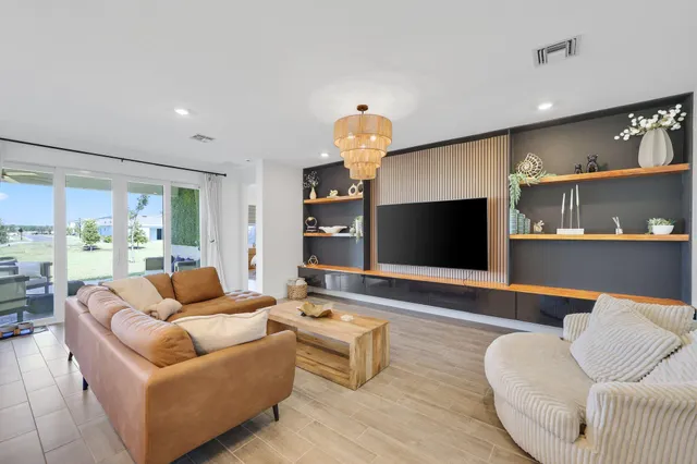 a kitchen with stainless steel appliances kitchen island granite countertop a stove a sink dishwasher and white cabinets with wooden floor