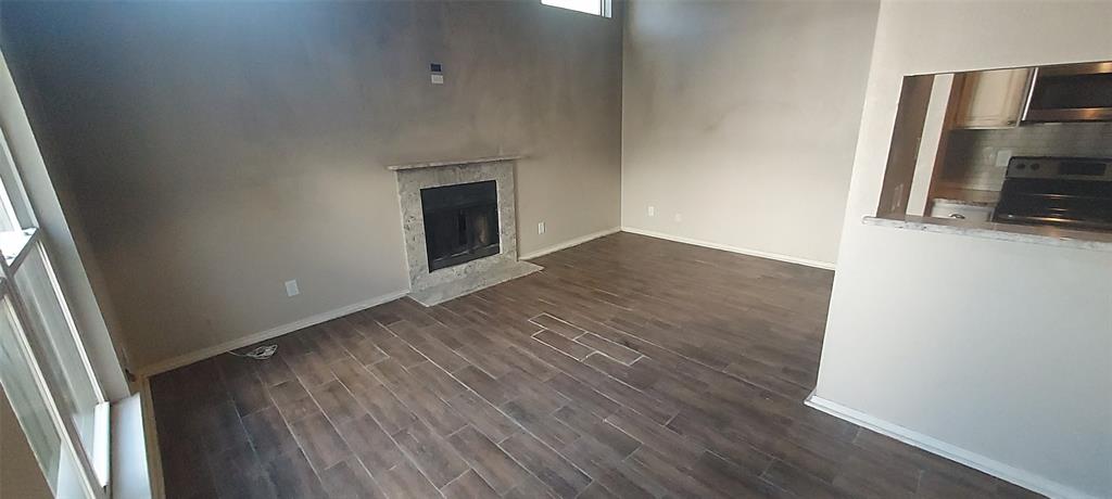 7340 Skillman Street, Unit 512 Dallas, TX 75231 - Photo 5 of 15 a view of a livingroom with wooden floor and a fireplace