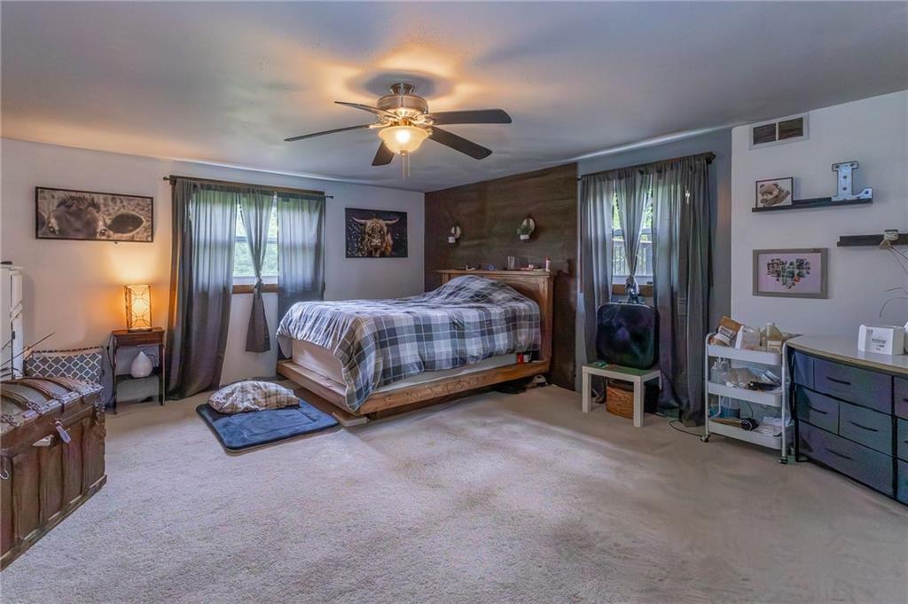 118 Eau Claire Road Boyers, PA 16020 - Photo 20 of 24 a spacious bedroom with a bed and a chandelier
