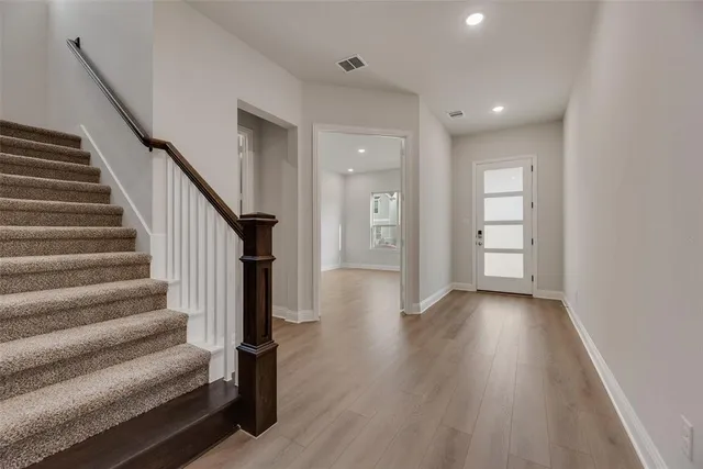 a view of a hallway with wooden floor and entryway