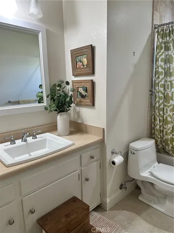 a bathroom with a granite countertop sink mirror vanity and toilet