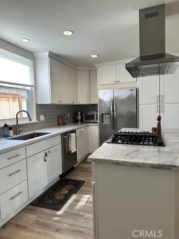 a kitchen with stainless steel appliances granite countertop a sink a stove and a refrigerator