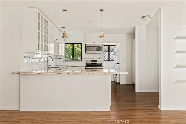 a kitchen with stainless steel appliances granite countertop a sink and cabinets
