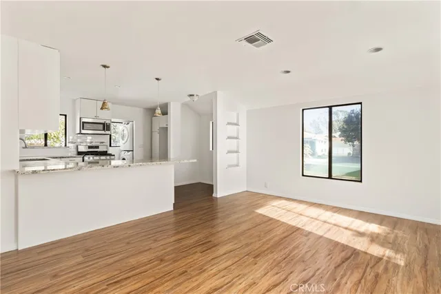 a view of a kitchen with wooden floor and a kitchen