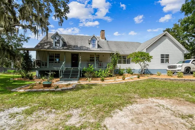 a view of a house with backyard sitting area and garden