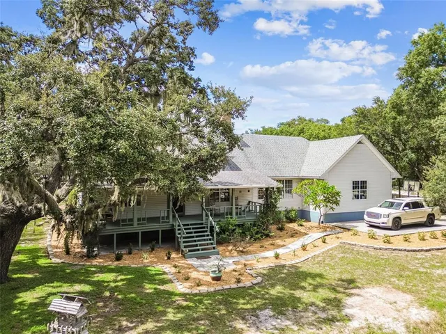 a backyard of a house with yard table and chairs