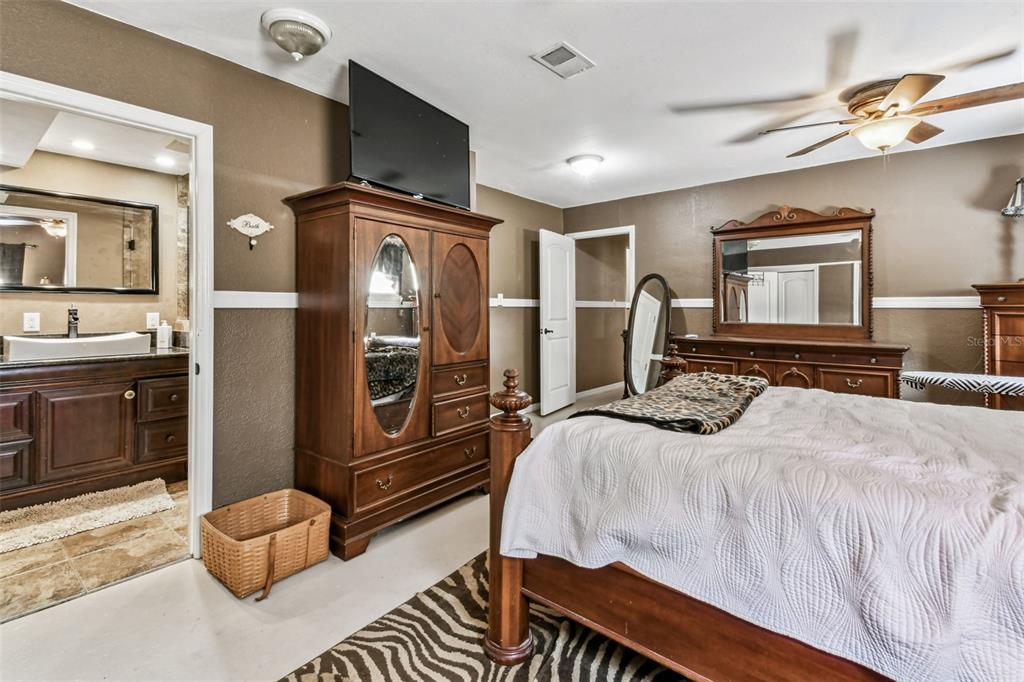 15019 Carlton Lake Road Wimauma, FL 33598 - Photo 39 of 89 a bedroom with a bed and dresser with mirror