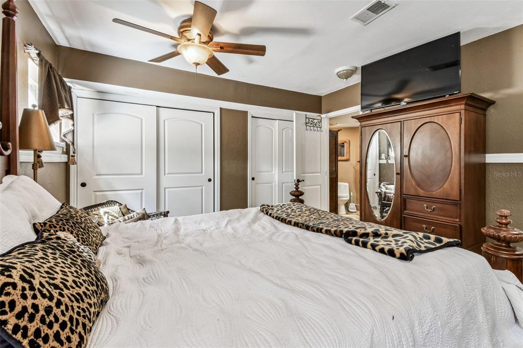 15019 Carlton Lake Road Wimauma, FL 33598 - Photo 40 of 89 a bedroom with a large bed and a chandelier