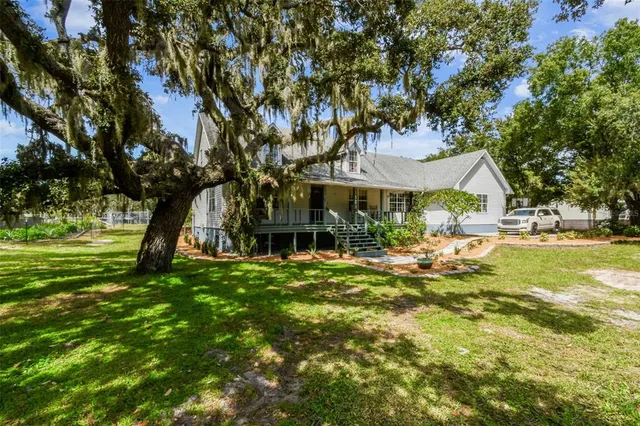 a view of a house with backyard sitting area and garden