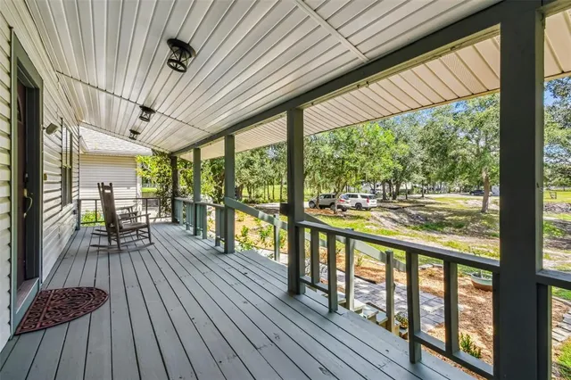 a view of a porch with furniture and wooden floor
