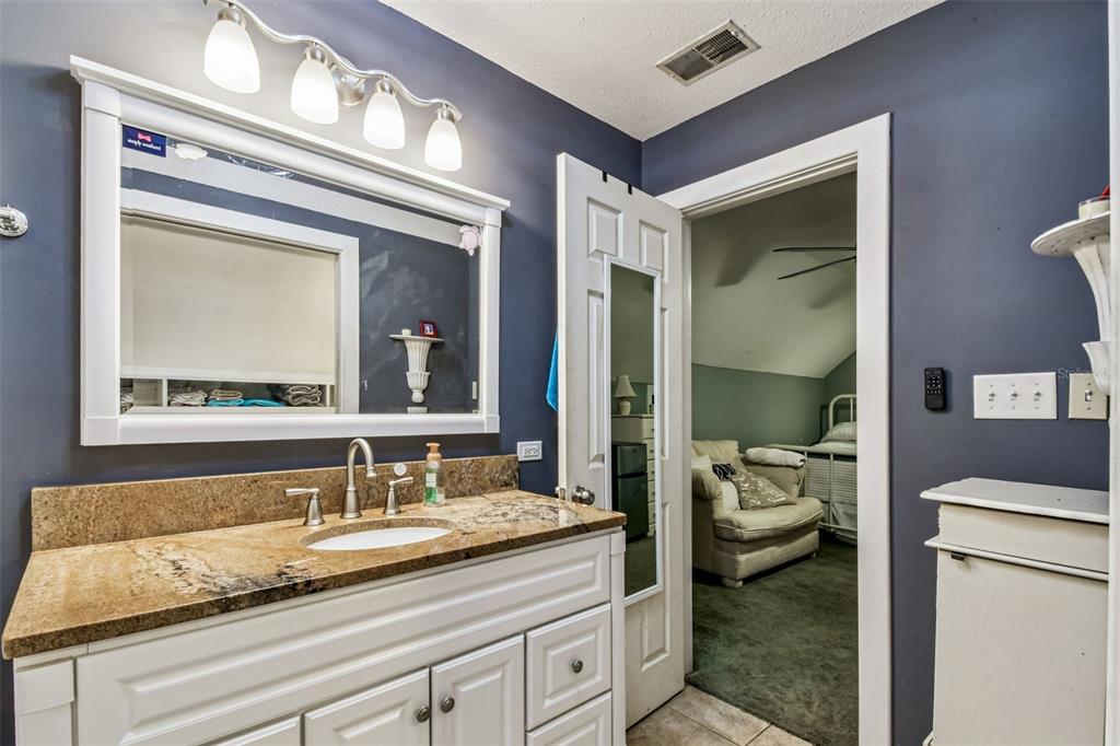 15019 Carlton Lake Road Wimauma, FL 33598 - Photo 78 of 89 a bathroom with a granite countertop sink and a mirror