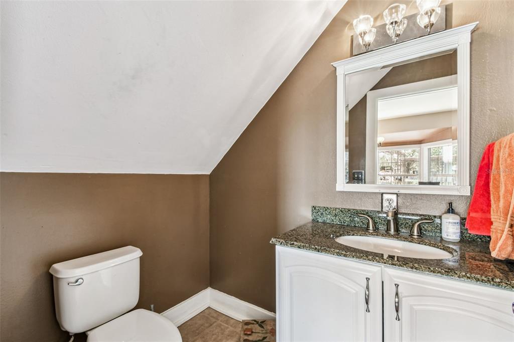 15019 Carlton Lake Road Wimauma, FL 33598 - Photo 84 of 89 a bathroom with a granite countertop sink a toilet and a mirror