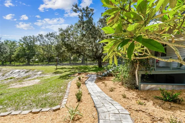 an open kitchen with stainless steel appliances kitchen island granite countertop a refrigerator a stove a dining table and chairs with wooden floor