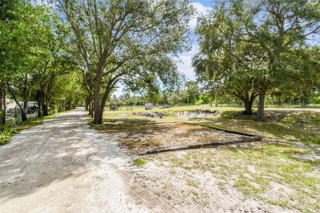 a dining room with wooden floor a chandelier a wooden table and chairs