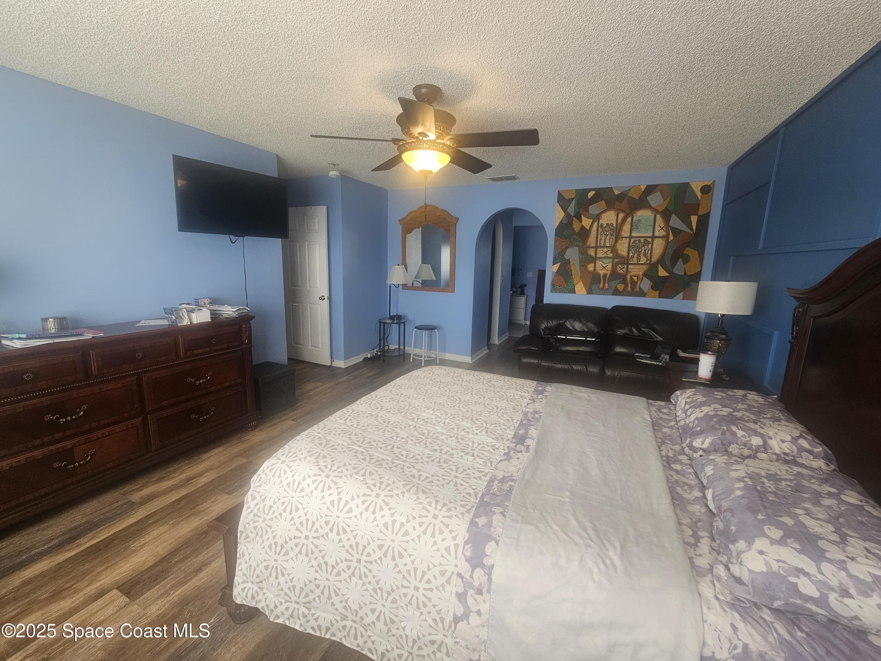 2240 Spring Creek Circle Palm Bay, FL 32905 - Photo 13 of 29 a bedroom with furniture and a flat screen tv