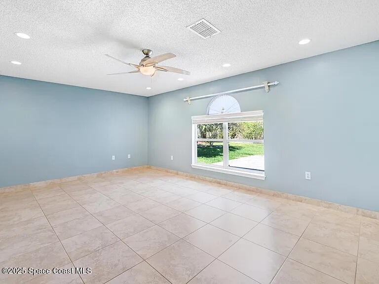 2240 Spring Creek Circle Palm Bay, FL 32905 - Photo 20 of 29 an empty room with windows and ceiling fan