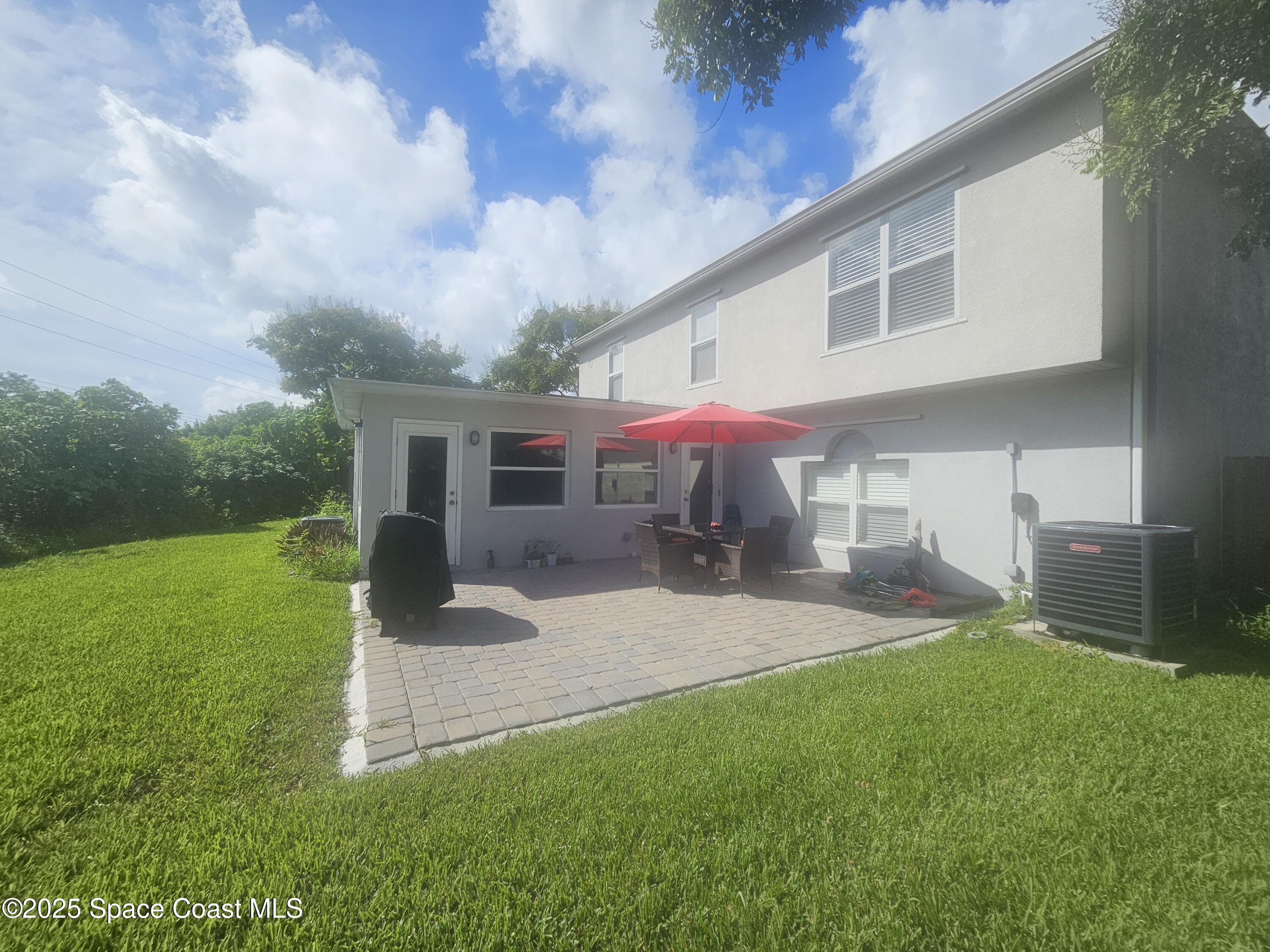 2240 Spring Creek Circle Palm Bay, FL 32905 - Photo 25 of 29 a backyard of a house with table and chairs