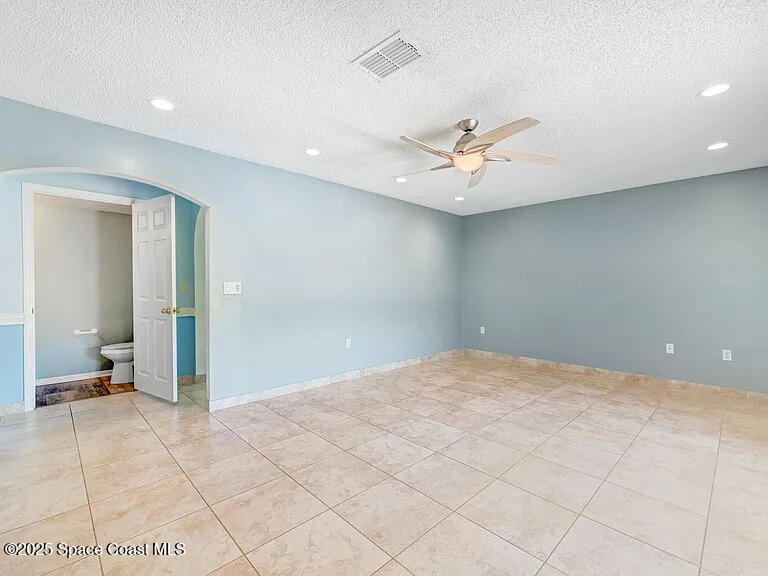 2240 Spring Creek Circle Palm Bay, FL 32905 - Photo 27 of 29 en empty room with fan and a ceiling fan