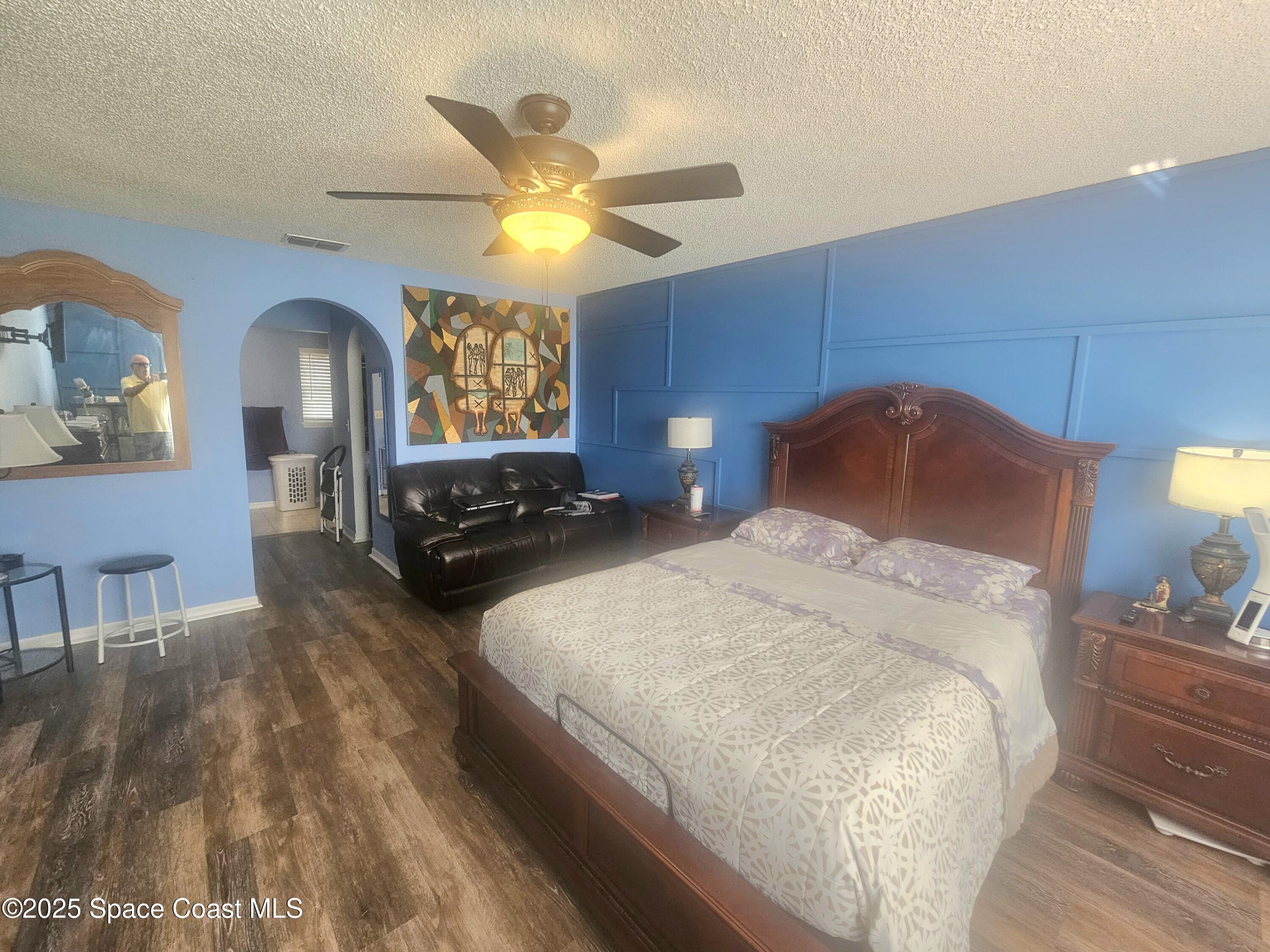 2240 Spring Creek Circle Palm Bay, FL 32905 - Photo 4 of 29 a bedroom with a bed and a chandelier