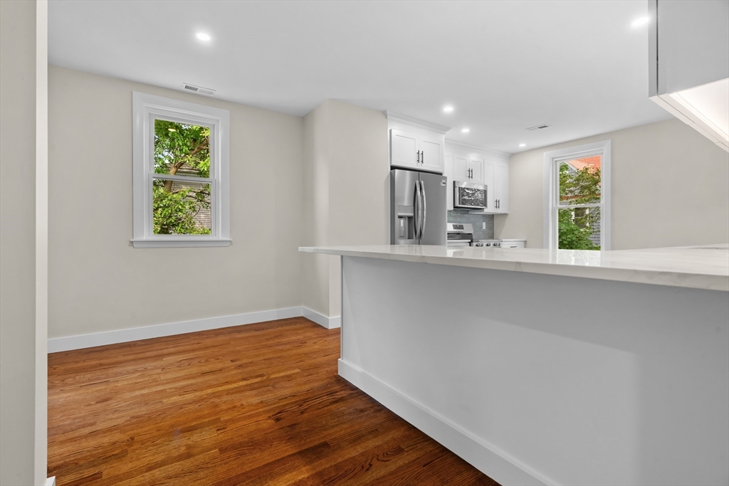37 George Street, Unit 37 Newton, MA 02458 - Photo 4 of 35 a kitchen with kitchen island a sink wooden floor and a refrigerator