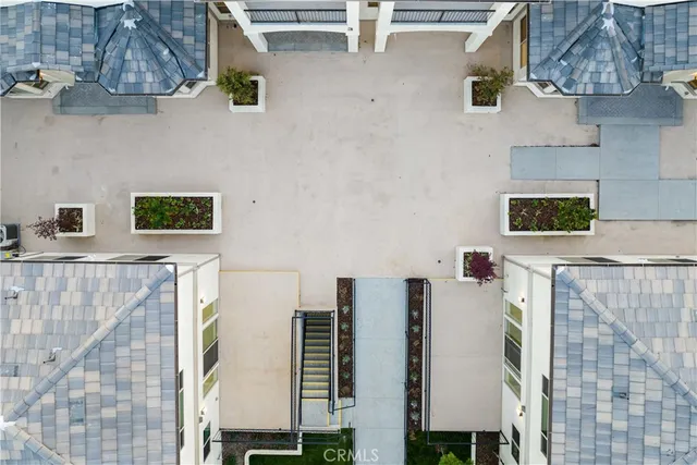 a front view of a house with a yard and potted plants
