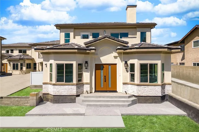 a view of a white house with a big yard and large trees
