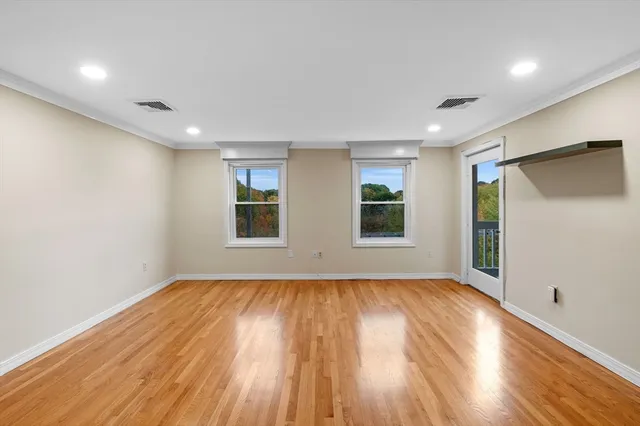 a view of room with window and wooden floor