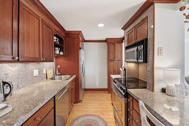 a kitchen with stainless steel appliances granite countertop a sink stove and refrigerator