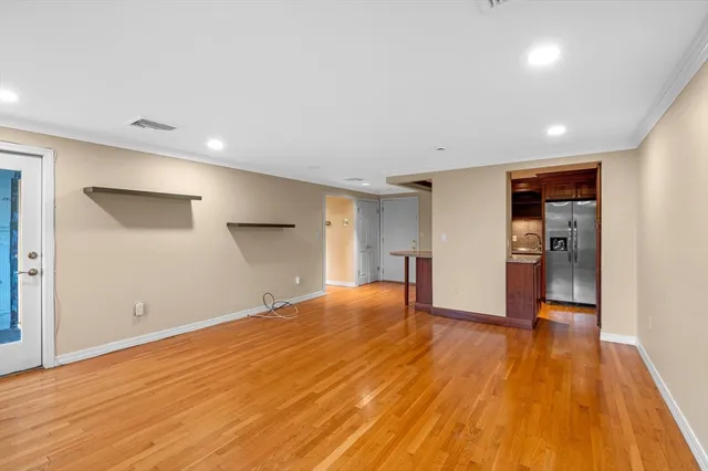 a view of empty room with wooden floor