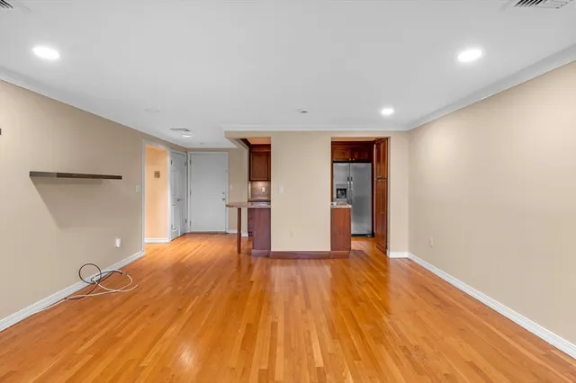 a view of empty room with wooden floor