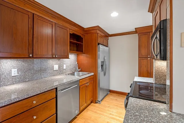 a kitchen with stainless steel appliances granite countertop a refrigerator and a sink