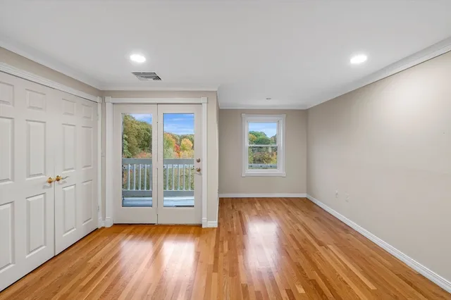 an empty room with wooden floor and windows