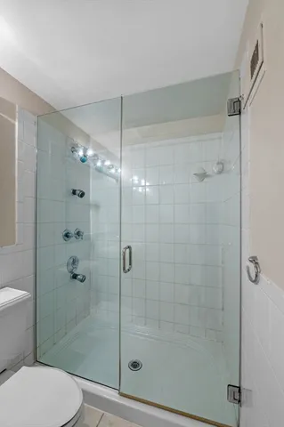 a bathroom with a shower a toilet and sink