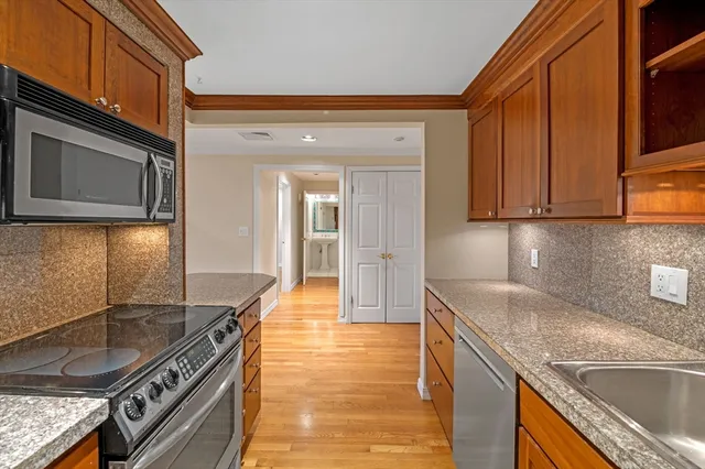 a kitchen with granite countertop a sink a stove and cabinets