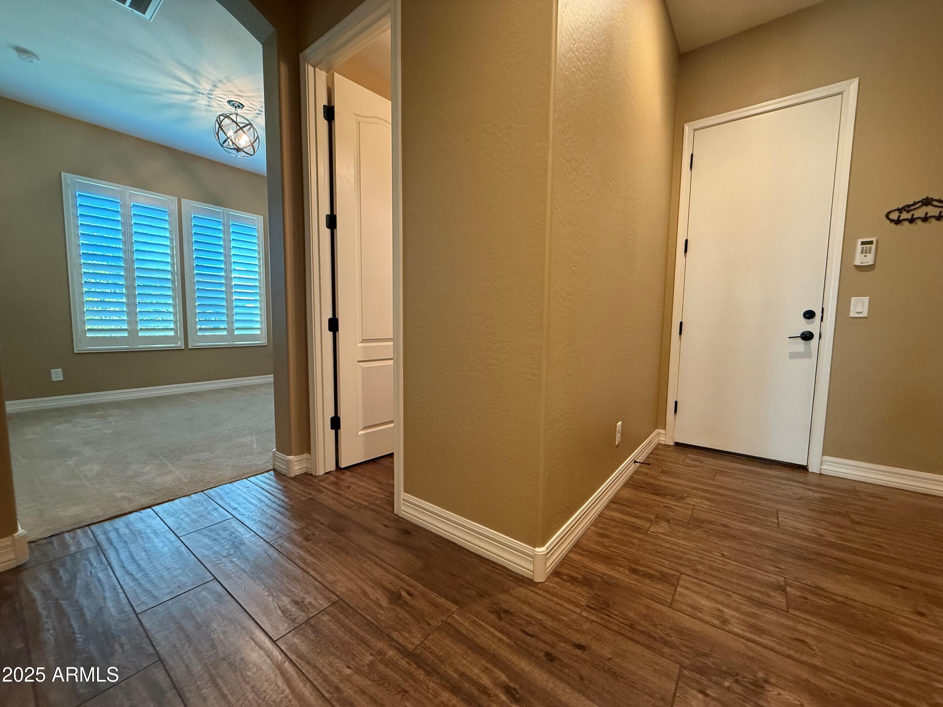 2709 North Black Rock Road Buckeye, AZ 85396 - Photo 8 of 74 an empty room with wooden floor and windows