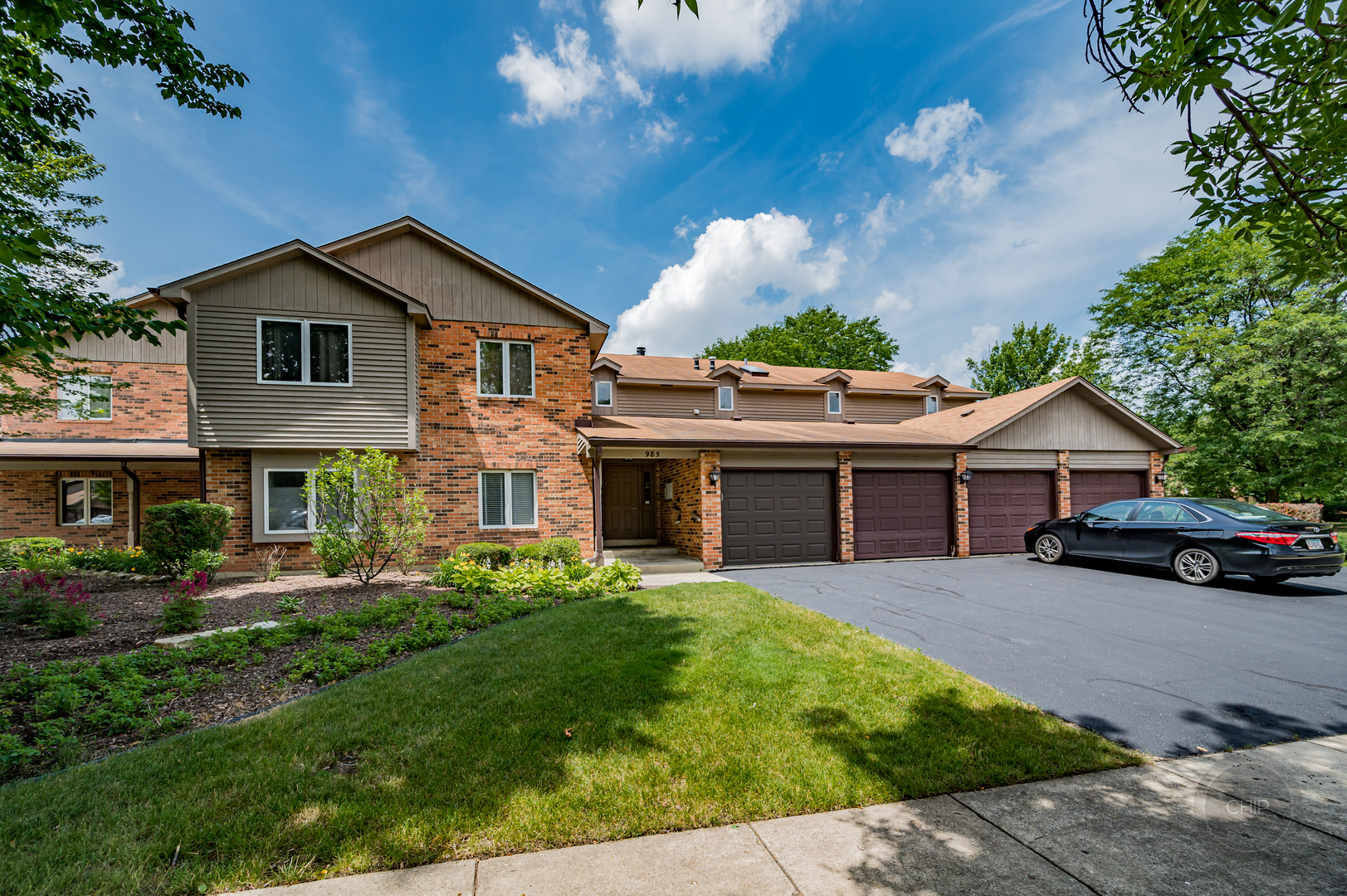 985 West Court, Unit D Naperville, IL 60563 - Photo 1 of 29 a front view of a house with a garden and plants
