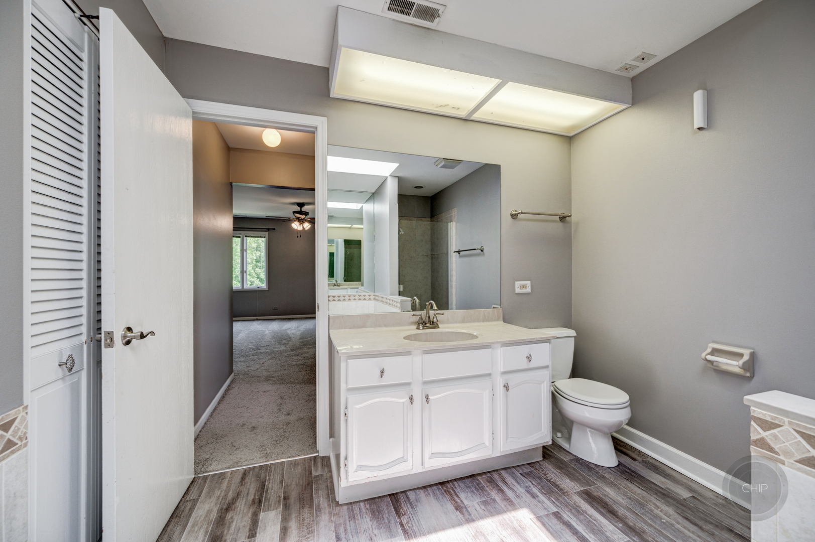 985 West Court, Unit D Naperville, IL 60563 - Photo 24 of 29 a spacious bathroom with a granite countertop sink a toilet and a mirror