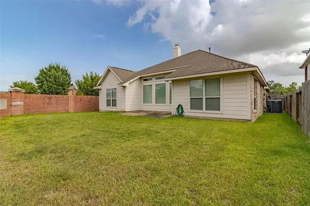 a front view of house with yard and trees in the background